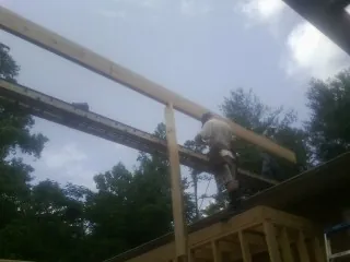 Carpenter setting a ridge beam over a new addition frame — Ice Dam Removal by Roofing Brothers in Knob Noster