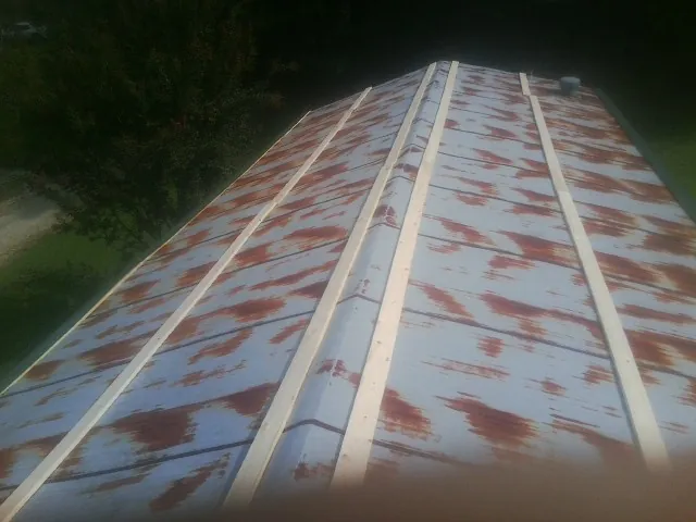 Rusted metal roof panels with new wood purlins before replacement — Storm Damage Roof Repair in Knob Noster by Roofing Brothers