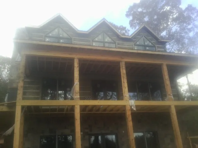 Dormers and porch framing on a large log home under construction — Roof Coating work by our crew in Knob Noster